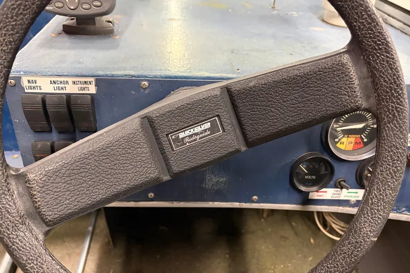 Slide: The Image of 1976 Monark 17 Utility Outboard dashboard with steering wheel and control switches. - 4