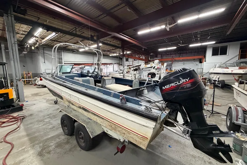 Slide: The Image of 1976 Monark 17 Utility Outboard boat with Mercury engine in a workshop setting. - 5