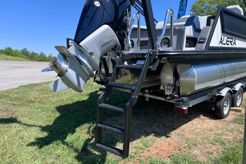 Slide: The Image of Alera M23L 2026 pontoon boat on trailer, featuring a powerful outboard motor. - 16