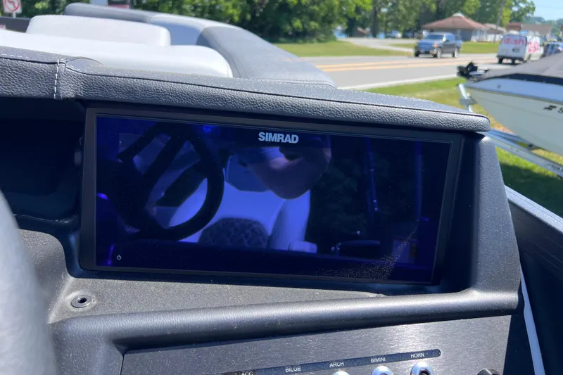 Slide: The Image of Simrad display on Alera M23L boat dashboard, 2026 model, with road and vehicles in background. - 6
