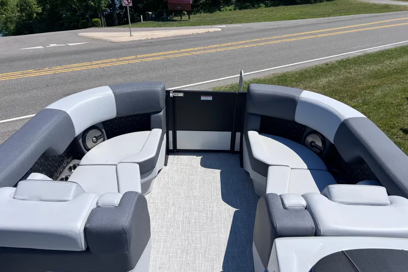 Slide: The Image of 2026 Alera M23L boat interior with gray seating, parked near a road. - 7