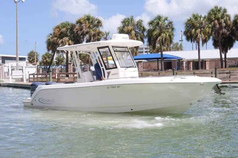 The Image of 2020 Robalo R272 Center Console boat on water, surrounded by palm trees. - 0