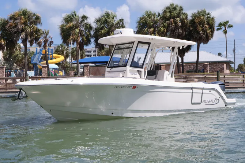 Slide: The Image of 2020 Robalo R272 Center Console boat on water, surrounded by palm trees. - 3
