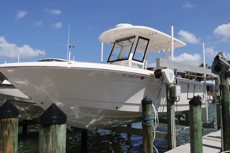 Slide: The Image of 2020 Robalo R272 Center Console boat docked at marina under clear blue sky. - 5