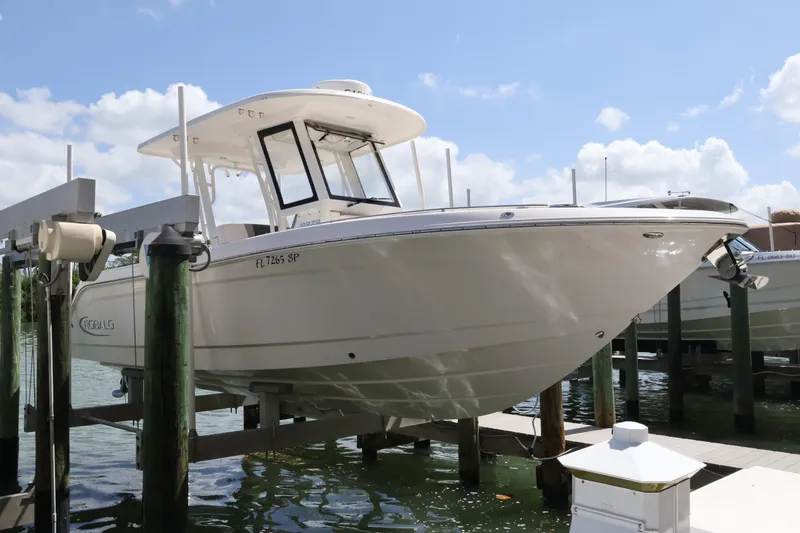 Slide: The Image of 2020 Robalo R272 Center Console boat docked on lift under clear sky. - 6