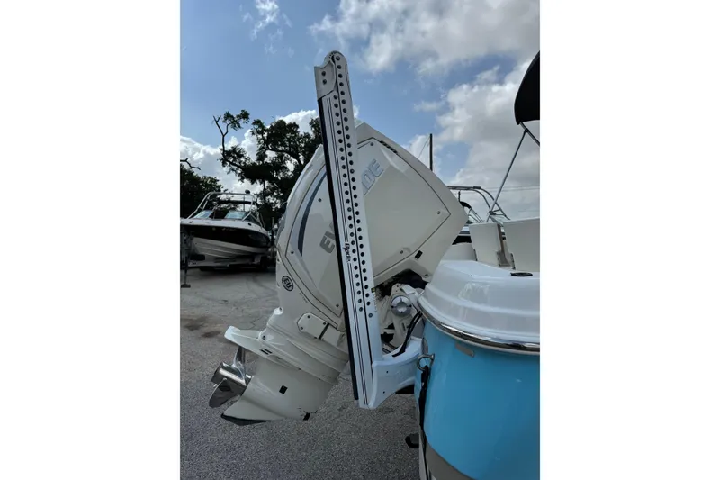 Slide: The Image of 2020 NauticStar 231 Hybrid boat with outboard motor, parked under cloudy sky. - 10