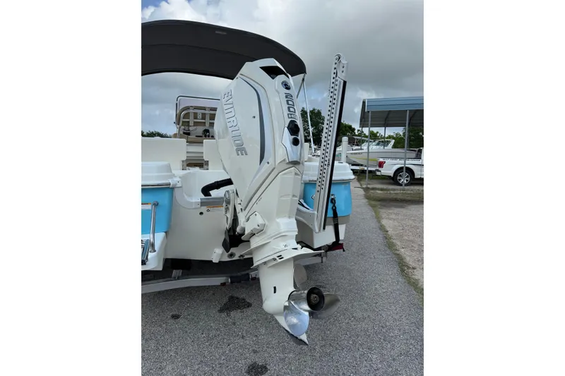 Slide: The Image of 2020 NauticStar 231 Hybrid boat with Evinrude outboard motor, parked on pavement. - 11
