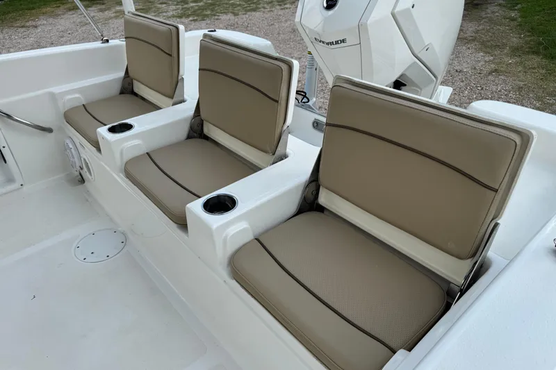 Slide: The Image of 2020 NauticStar 231 Hybrid boat seats with beige cushions and cup holders. - 13