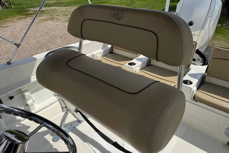 Slide: The Image of 2020 NauticStar 231 Hybrid boat interior with tan seating and steering wheel. - 18
