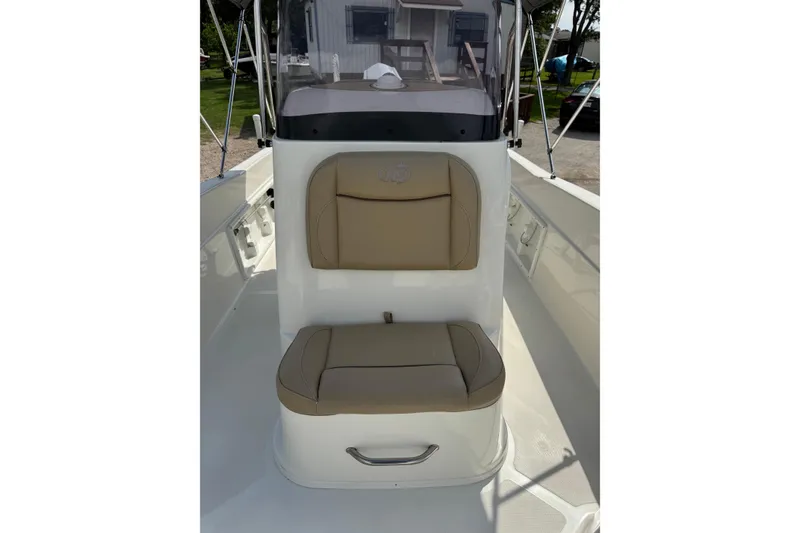 Slide: The Image of 2020 NauticStar 231 Hybrid boat interior with tan cushioned seating and console. - 26