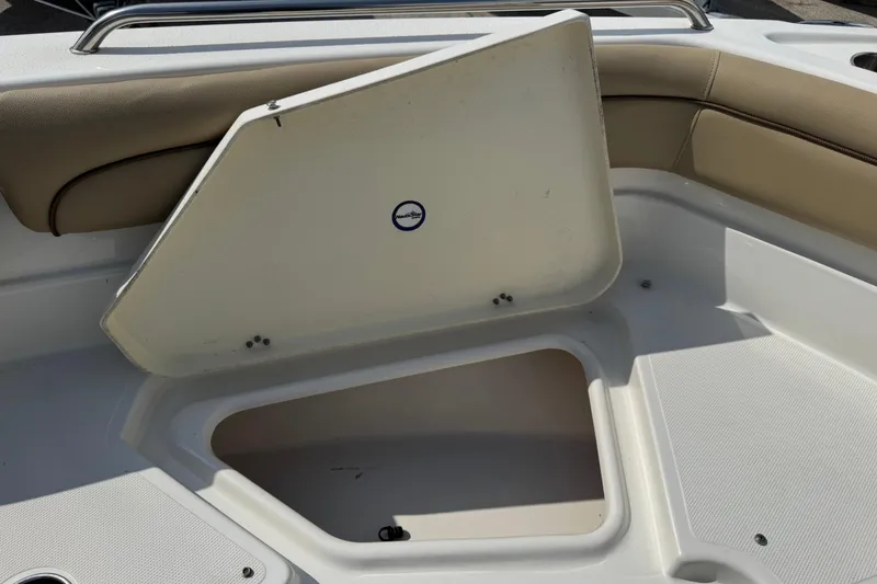 Slide: The Image of Open storage compartment on a 2020 NauticStar 231 Hybrid boat, featuring beige seating. - 28