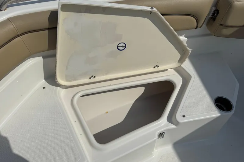 Slide: The Image of Open storage compartment on a 2020 NauticStar 231 Hybrid boat, featuring beige seating. - 30