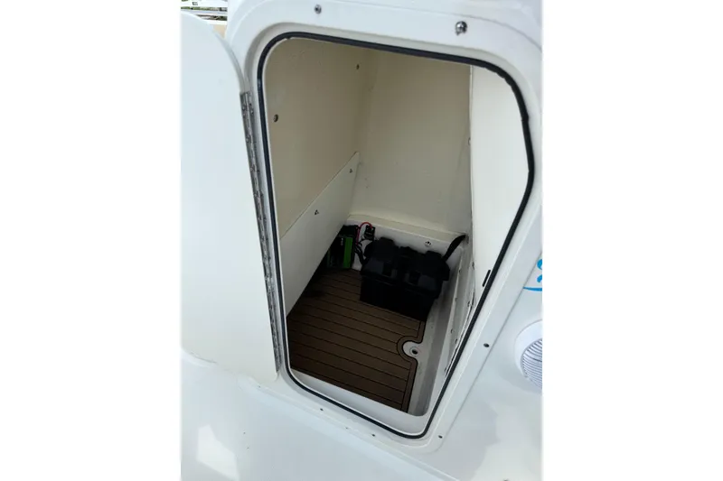 Slide: The Image of 2020 NauticStar 231 Hybrid boat storage compartment with wooden flooring and equipment. - 31