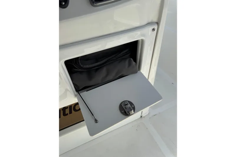 Slide: The Image of Storage compartment on a 2020 NauticStar 231 Hybrid boat, featuring a secure latch. - 33