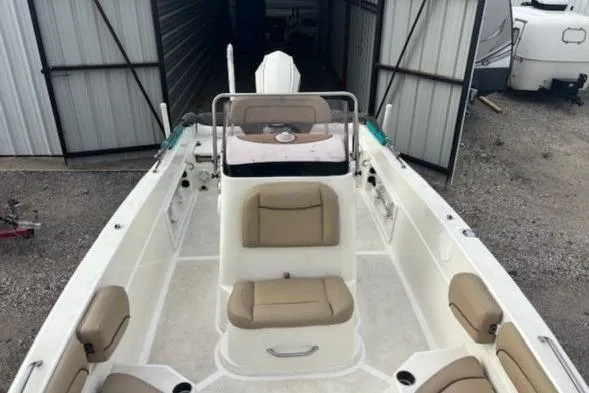 Slide: The Image of 2020 NauticStar 231 Hybrid boat with beige seating, docked in a storage area. - 35