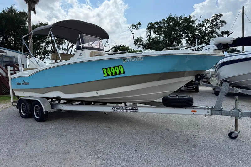 Slide: The Image of 2020 NauticStar 231 Hybrid boat on trailer, priced at $34,999, displayed outdoors. - 7