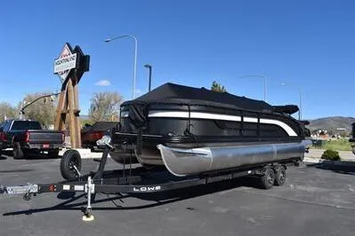 Slide: The Image of 2026 Lowe SF 232 Sport Fish pontoon boat on trailer in parking lot. - 1