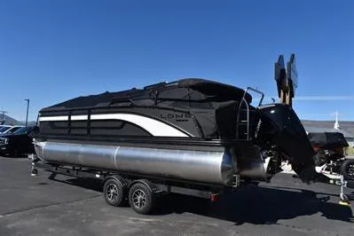 Slide: The Image of 2026 Lowe SF 232 Sport Fish pontoon boat on trailer, parked outdoors. - 2