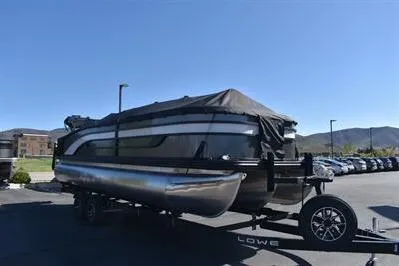 Slide: The Image of 2026 Lowe SF 232 Sport Fish pontoon boat on trailer, covered, in parking lot. - 5