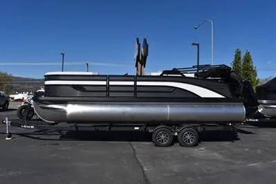 Slide: The Image of 2026 Lowe SF 232 Sport Fish pontoon boat on trailer, parked outdoors under clear blue sky. - 7