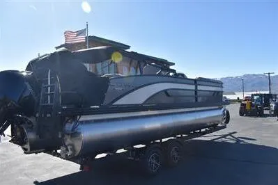 Slide: The Image of 2026 Lowe SF 232 Sport Fish pontoon boat on trailer, outdoors with mountains in background. - 9