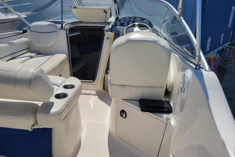 Slide: The Image of 2003 Bayliner 245 boat interior with white seating and helm, showcasing modern design. - 3