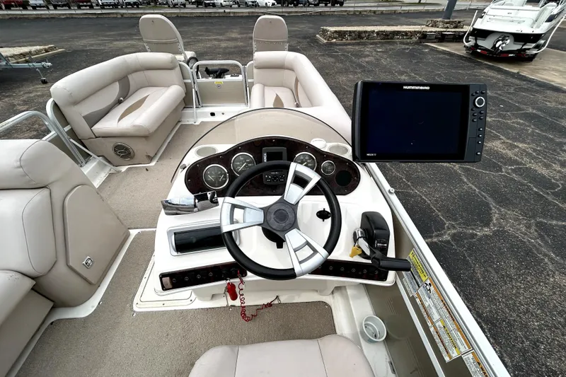 Slide: The Image of 2014 Hurricane FunDeck 226F boat interior with steering wheel and navigation system. - 24