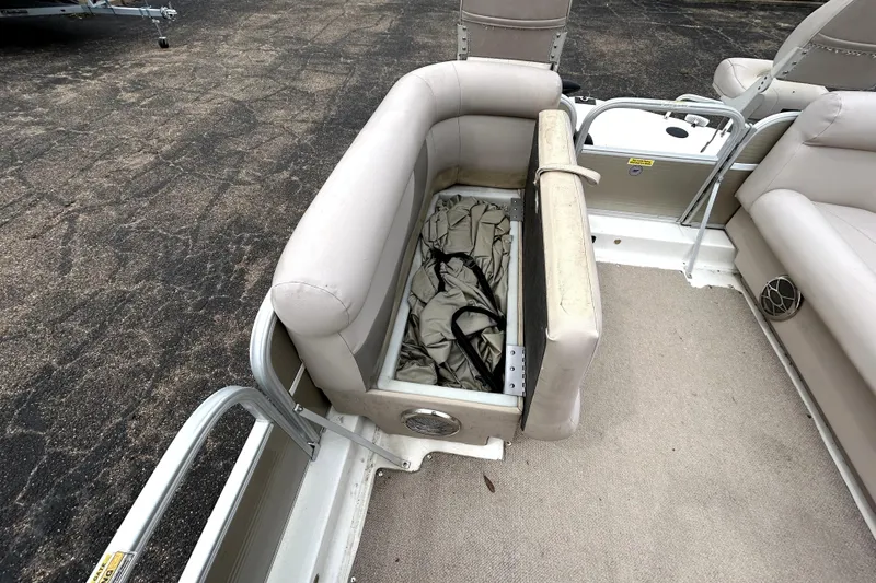 Slide: The Image of 2014 Hurricane FunDeck 226F boat interior with open storage compartment and beige seating. - 27