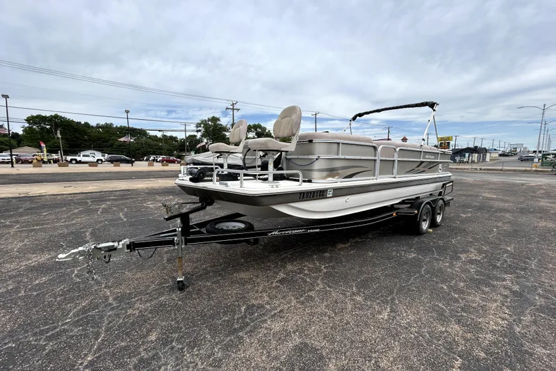 Slide: The Image of 2014 Hurricane FunDeck 226F boat on trailer in parking lot, under cloudy sky. - 3