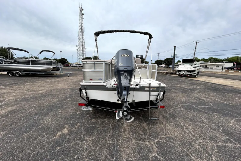 Slide: The Image of 2014 Hurricane FunDeck 226F boat with outboard motor in a parking lot. - 6