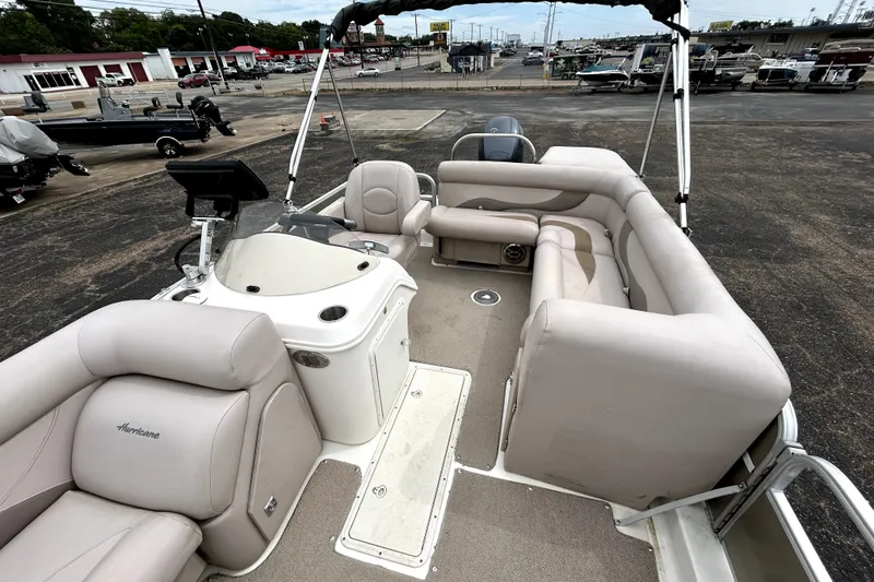 Slide: The Image of 2014 Hurricane FunDeck 226F boat with spacious seating and modern helm, parked at a marina. - 9