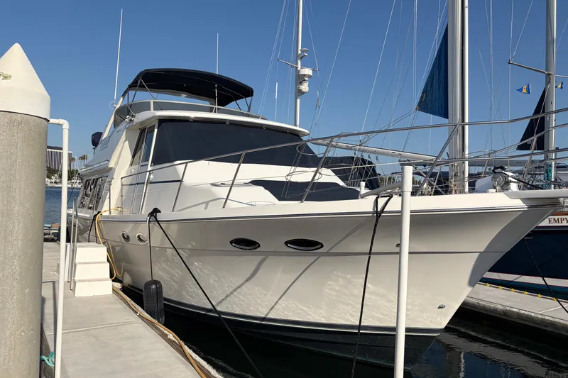 The Image of 2005 Meridian 490 Pilothouse yacht docked at marina under clear blue sky. - 1