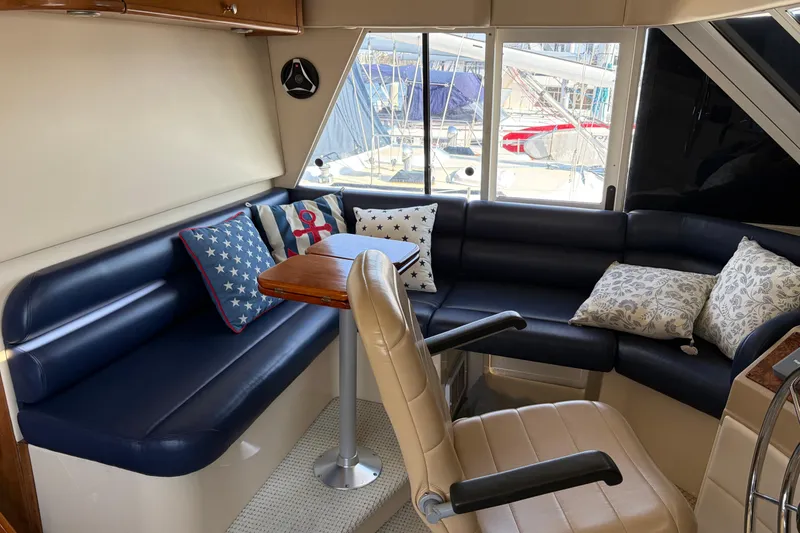Slide: The Image of Interior of 2005 Meridian 490 Pilothouse with navy seating and nautical-themed pillows. - 14