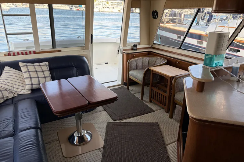 Slide: The Image of Interior of 2005 Meridian 490 Pilothouse yacht with seating and table, overlooking marina. - 3