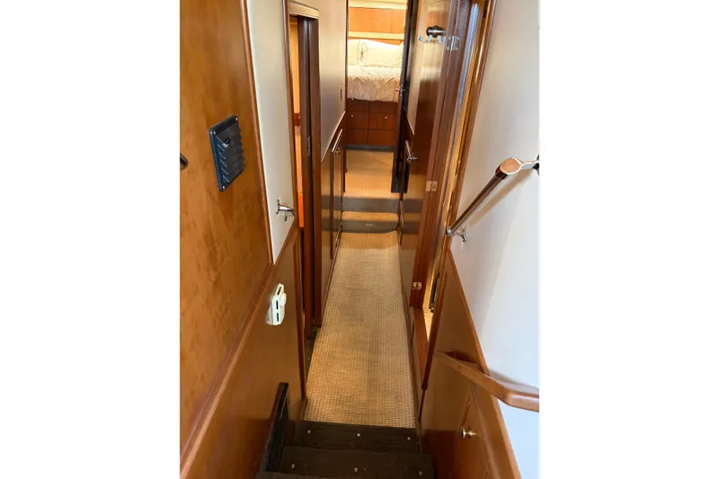 Slide: The Image of Interior hallway of 2005 Meridian 490 Pilothouse yacht, featuring wooden paneling and carpeted flooring. - 7