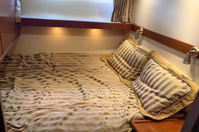 Slide: The Image of Cozy cabin interior of 2005 Meridian 490 Pilothouse with striped bedding and warm lighting. - 8