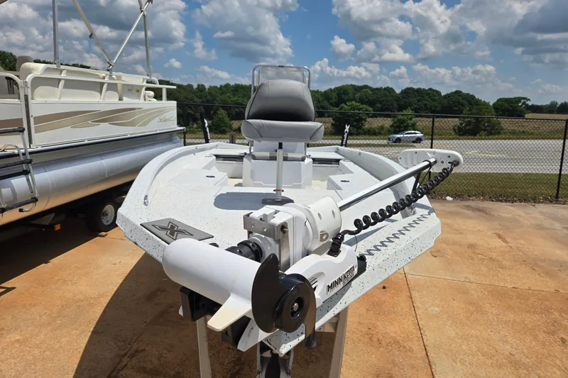 Slide: The Image of 2023 Xpress H22B Bay boat with Minn Kota trolling motor, parked outdoors. - 10