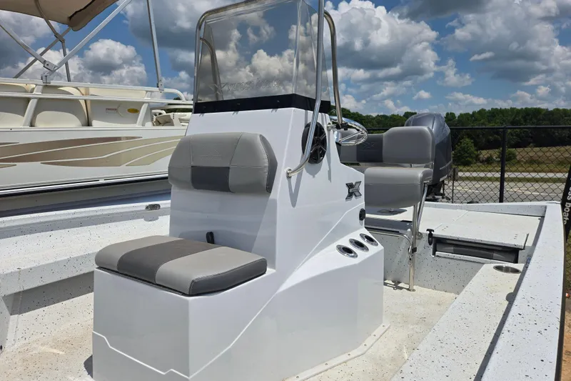 Slide: The Image of 2023 Xpress H22B Bay boat with seating and steering console under a cloudy sky. - 15