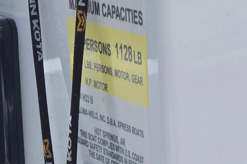 Slide: The Image of 2023 Xpress H22B Bay boat capacity label, showing maximum weight and safety standards. - 5