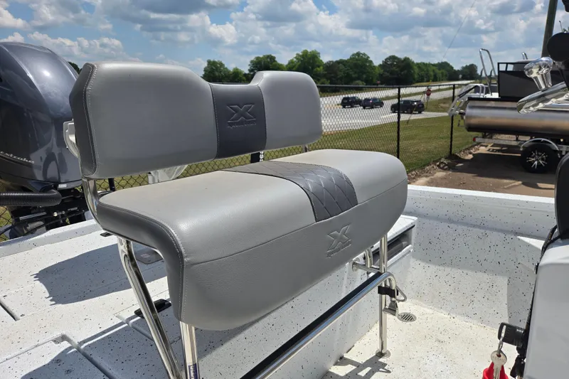 Slide: The Image of 2023 Xpress H22B Bay boat seat with gray upholstery and chrome accents under a sunny sky. - 8