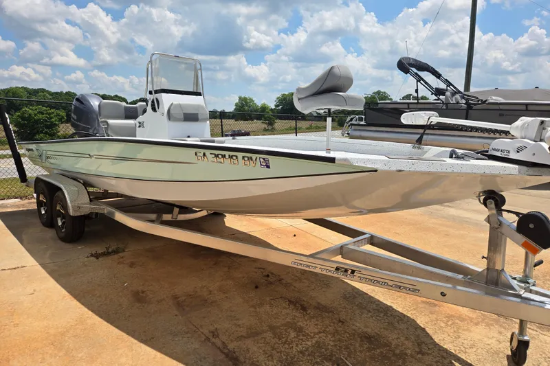 Slide: The Image of 2023 Xpress H22B Bay boat on trailer, parked outdoors under a cloudy sky. - 9