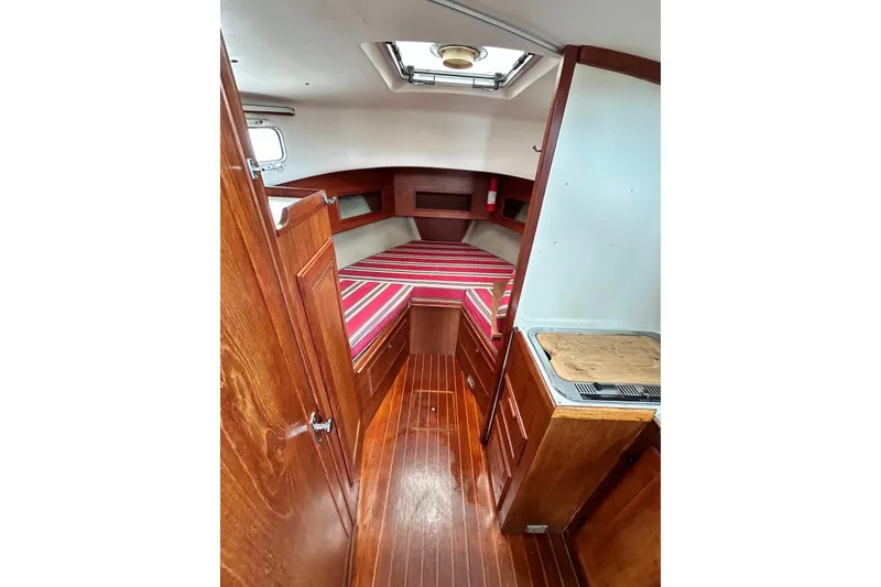 Slide: The Image of Interior of 1987 Cape Dory 28 Flybridge with wood finish and striped bedding. - 5
