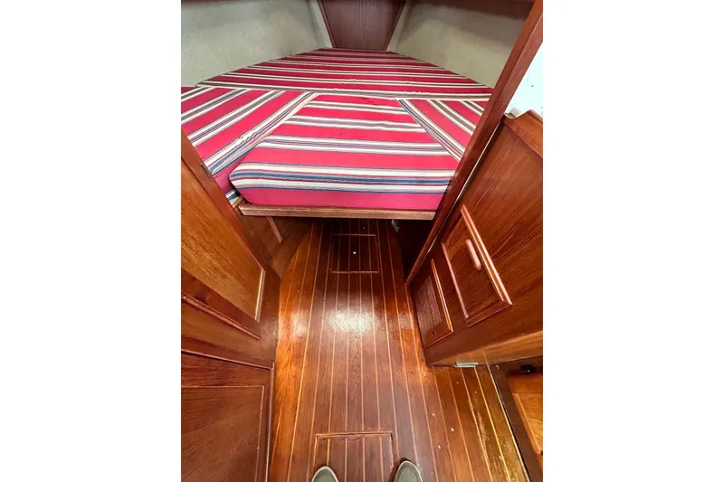 Slide: The Image of Interior of 1987 Cape Dory 28 Flybridge with striped bedding and wooden flooring. - 6