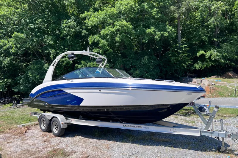 The Image of 2016 Chaparral Vortex 243 VRX boat on trailer, surrounded by lush greenery. - 0