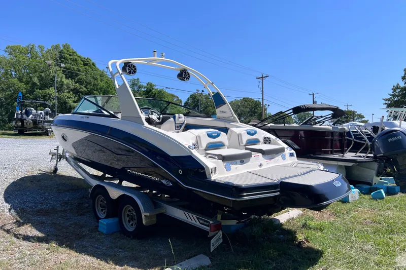 Slide: The Image of 2016 Chaparral Vortex 243 VRX boat on trailer, parked outdoors under clear blue sky. - 3