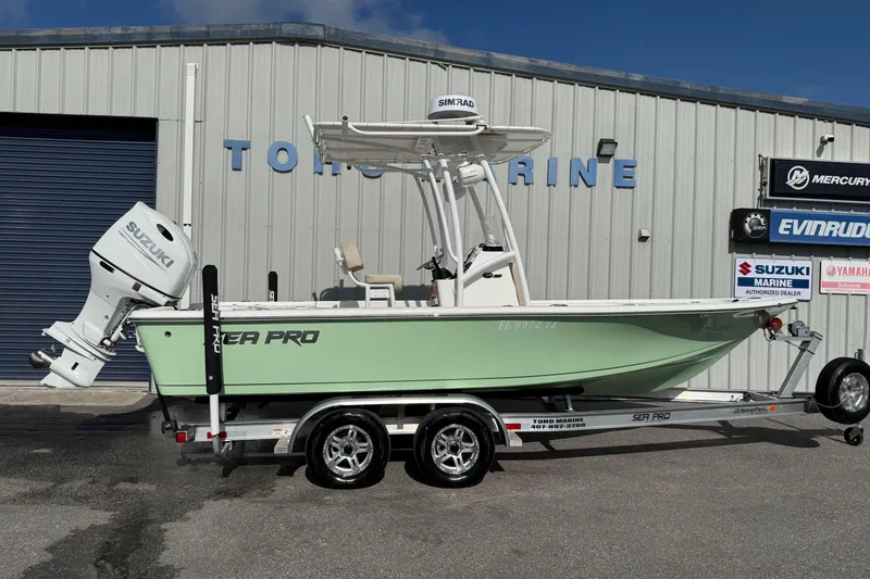 The Image of 2024 Sea Pro 210 Bay boat on trailer, featuring Suzuki outboard motor. - 0