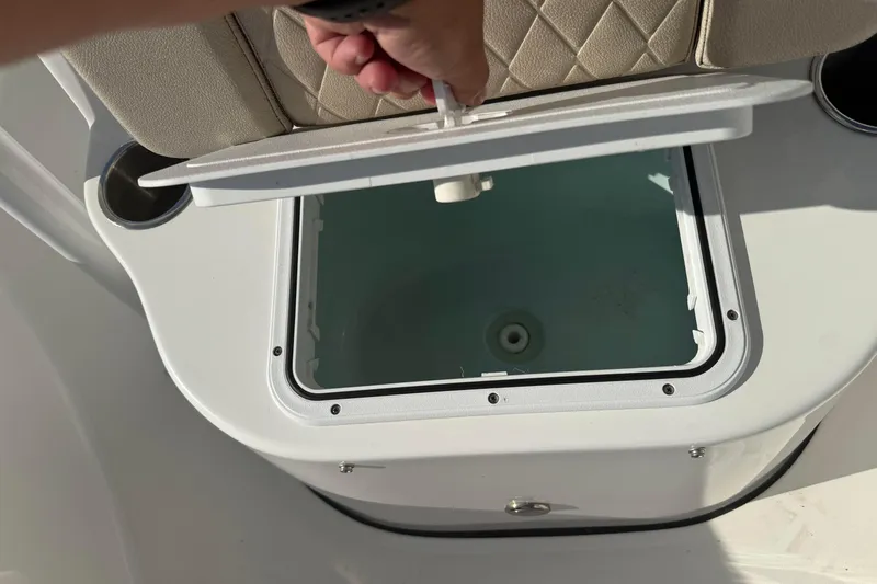 Slide: The Image of 2024 Sea Pro 210 Bay boat storage compartment with open lid and cushioned seating. - 13