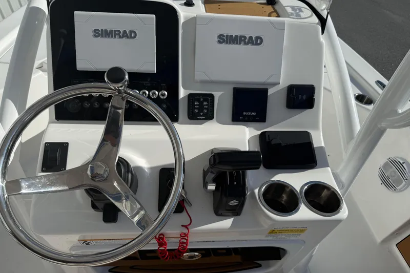 Slide: The Image of 2024 Sea Pro 210 Bay boat dashboard with Simrad displays and steering wheel. - 16