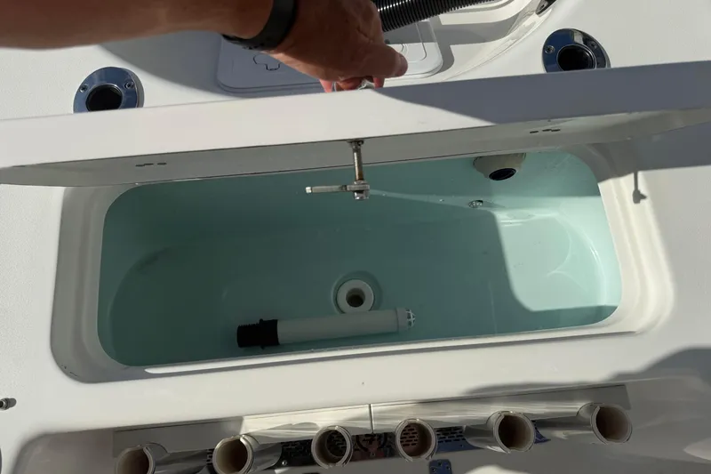 Slide: The Image of Livewell compartment on a 2024 Sea Pro 210 Bay boat, showcasing interior features. - 22