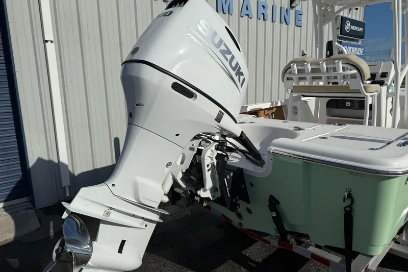 Slide: The Image of 2024 Sea Pro 210 Bay boat with Suzuki outboard motor, docked at a marine facility. - 5